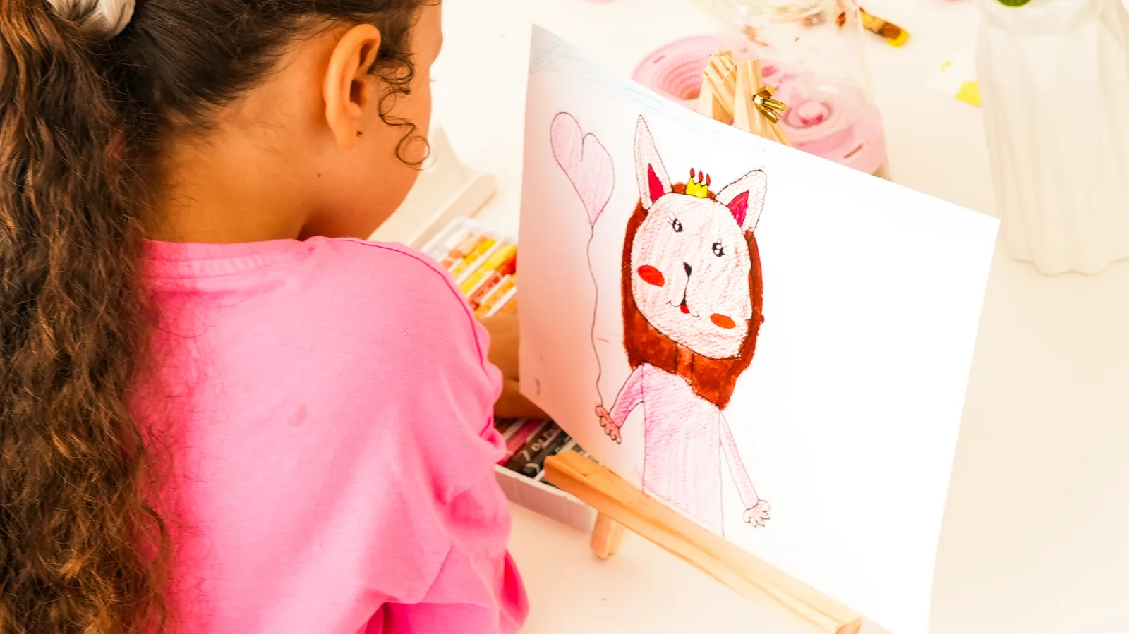 Fillette dessinant un lapin princesse aux feutres sur chevalet à NX Paintball