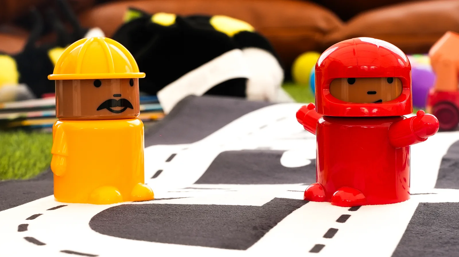 Figurines chantier et cosmonaute colorées sur tapis circuit pour atelier enfant
