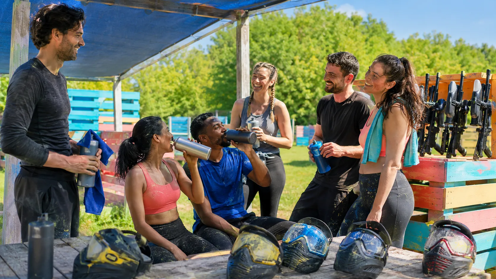 Six amis font une pause hydratation pendant une sortie paintball estivale près de Paris