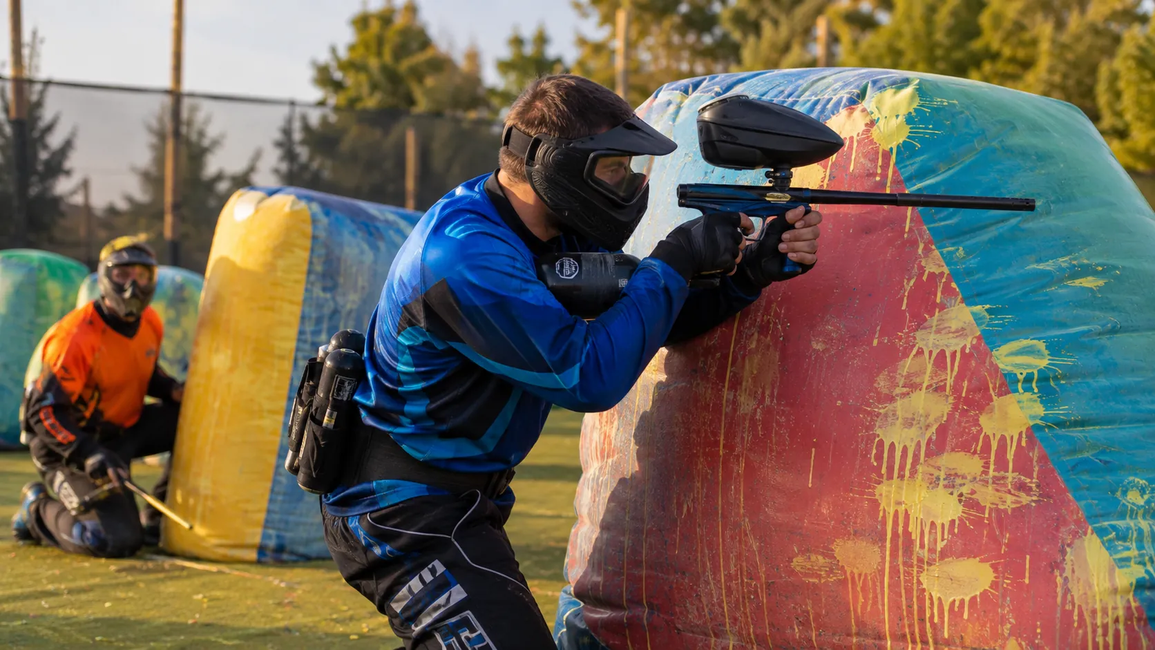 Deux joueurs équipés appliquent les techniques de visée et de déplacement derrière des obstacles colorés