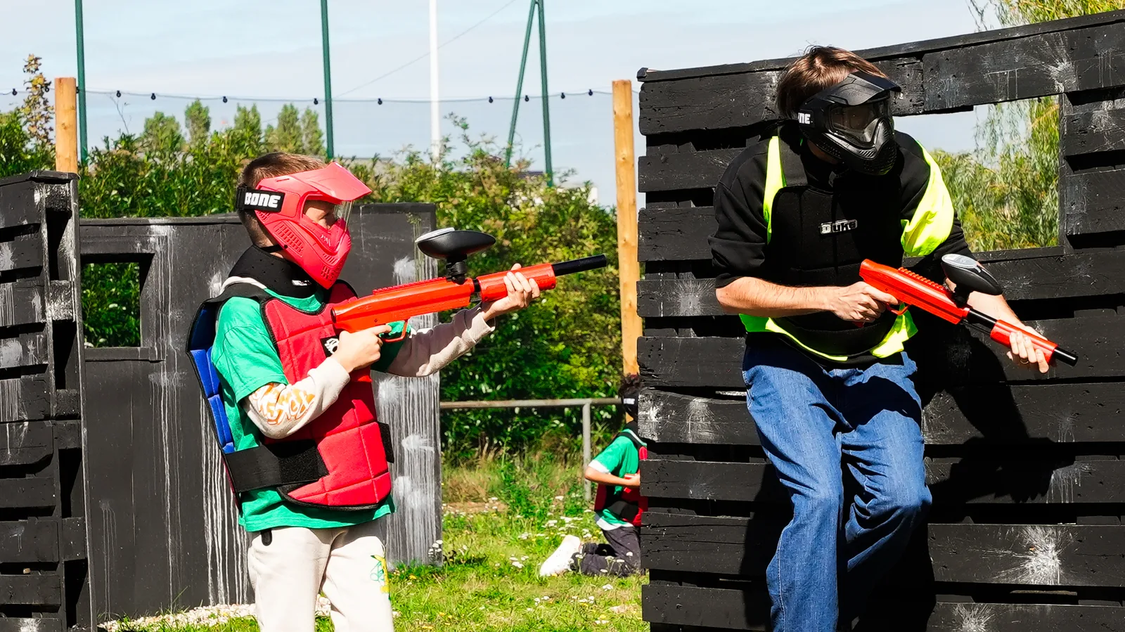 Partie de paintball enfant et adulte derrière palissade à Neuilly-sur-Marne