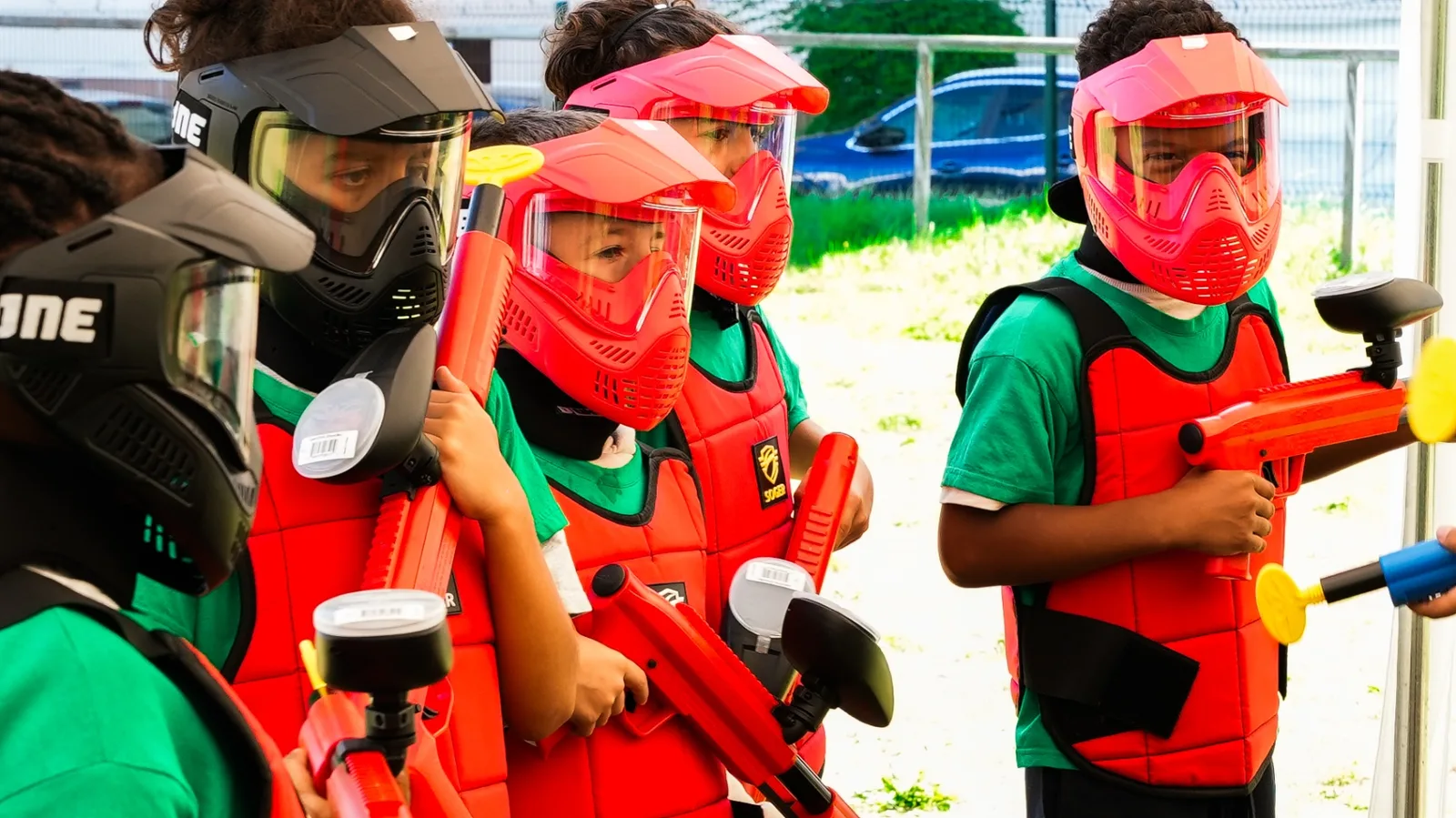 Enfants avec lanceurs paintball basse pression prêts à jouer sur le terrain