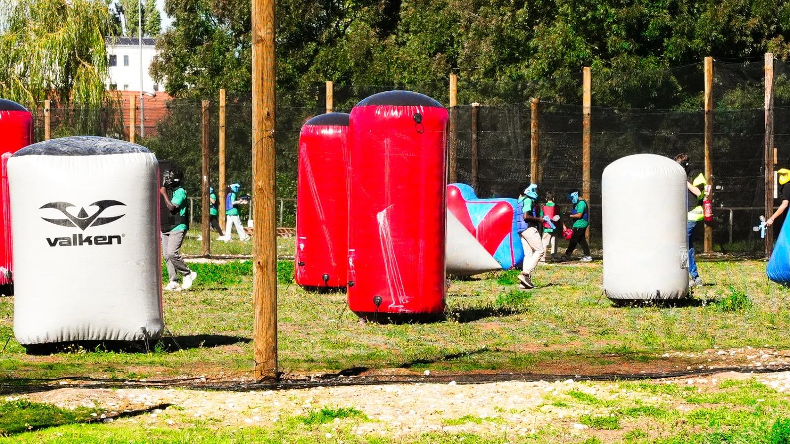 Enfants en partie paintball sur terrain airball avec obstacles gonflables rouges et blancs