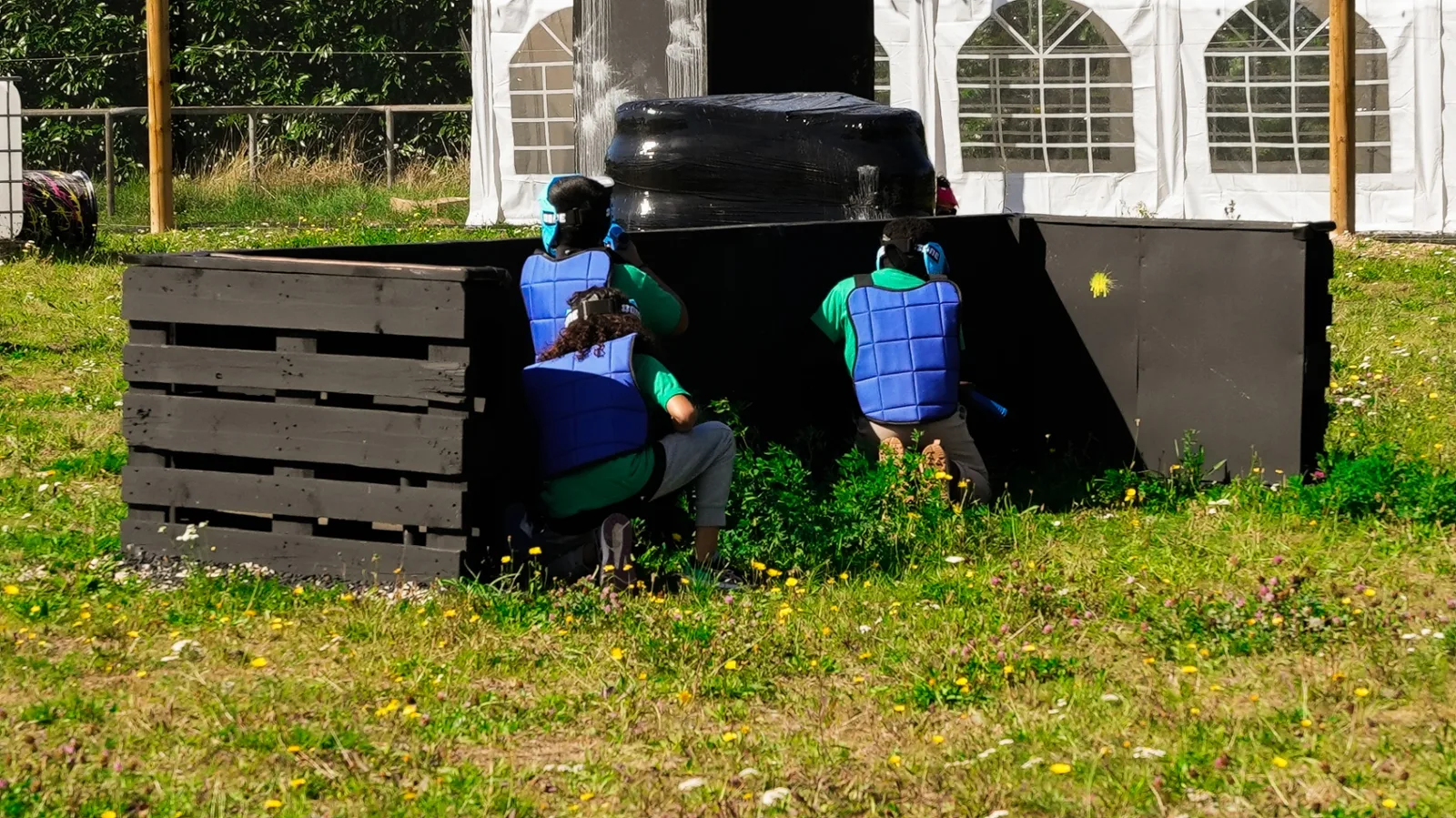 Enfants embusqués derrière des obstacles lors d'une partie de paintball
