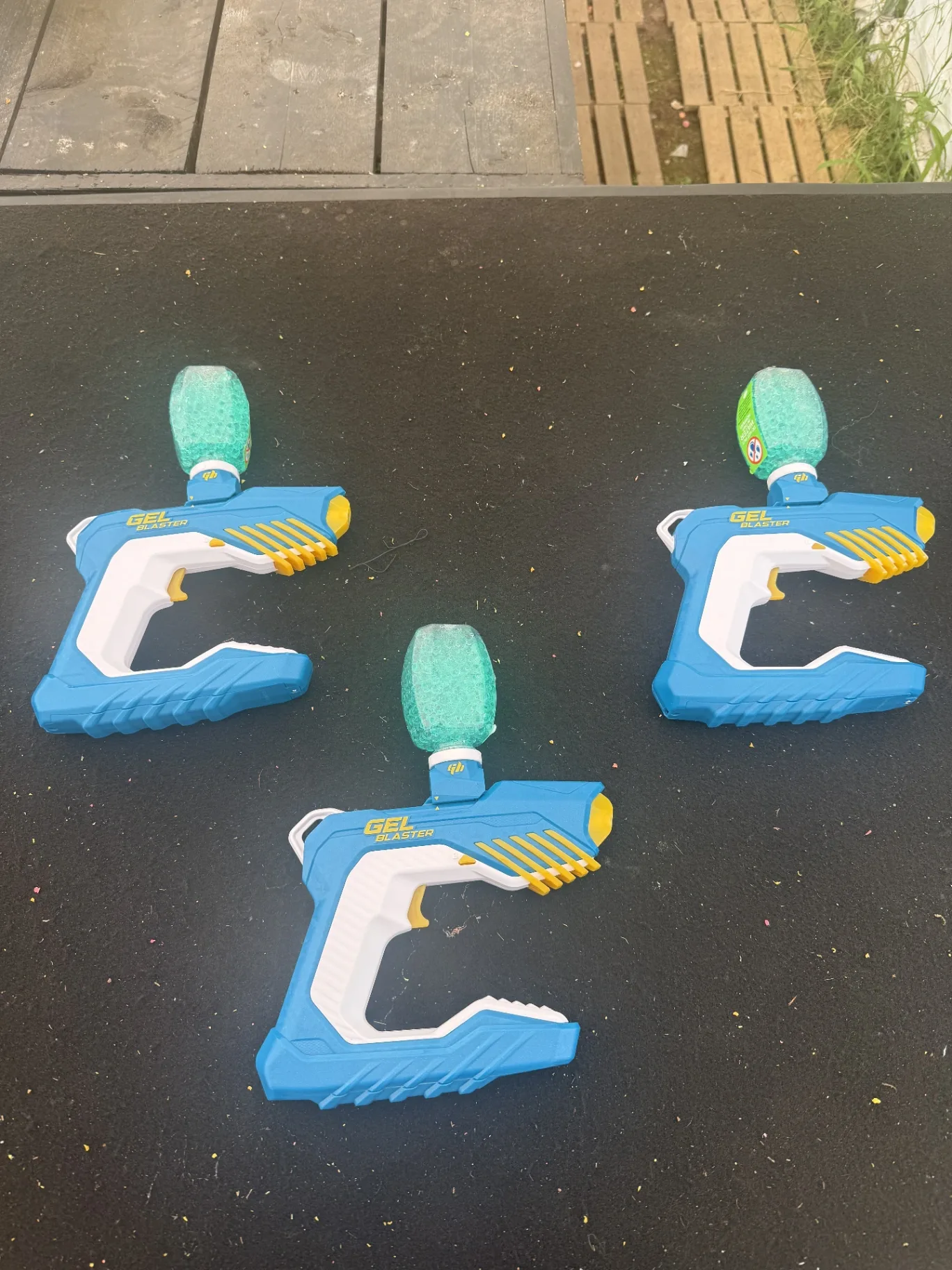 Trois lanceurs Gel Blaster bleus chargés de billes de gel vertes à NX Paintball Neuilly-sur-Marne