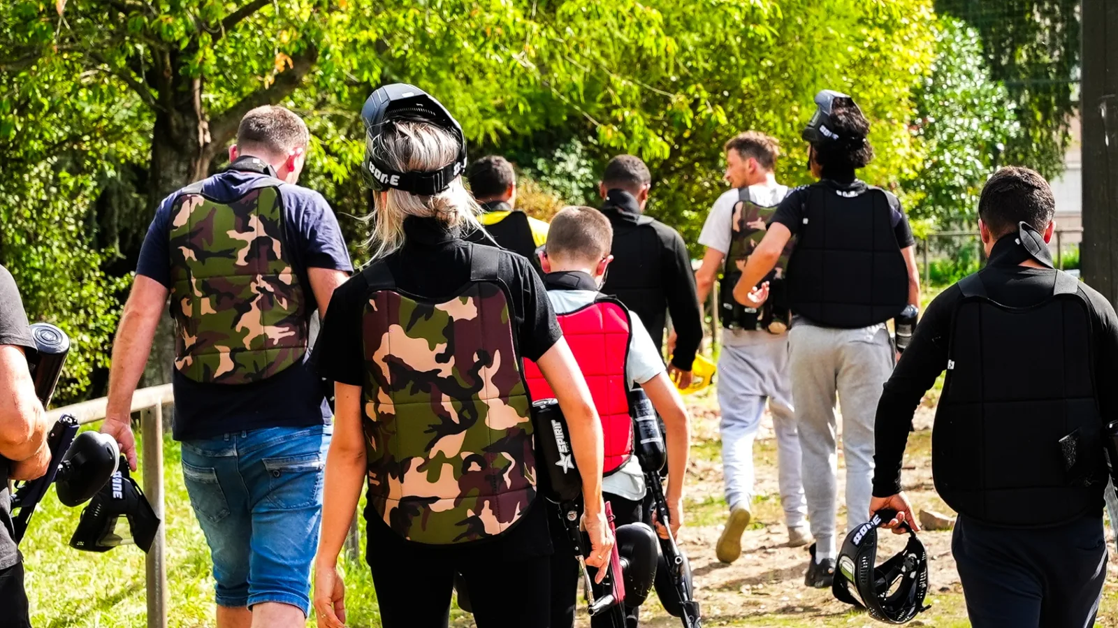 Groupe de joueurs équipés en route pour une partie de paintball adulte