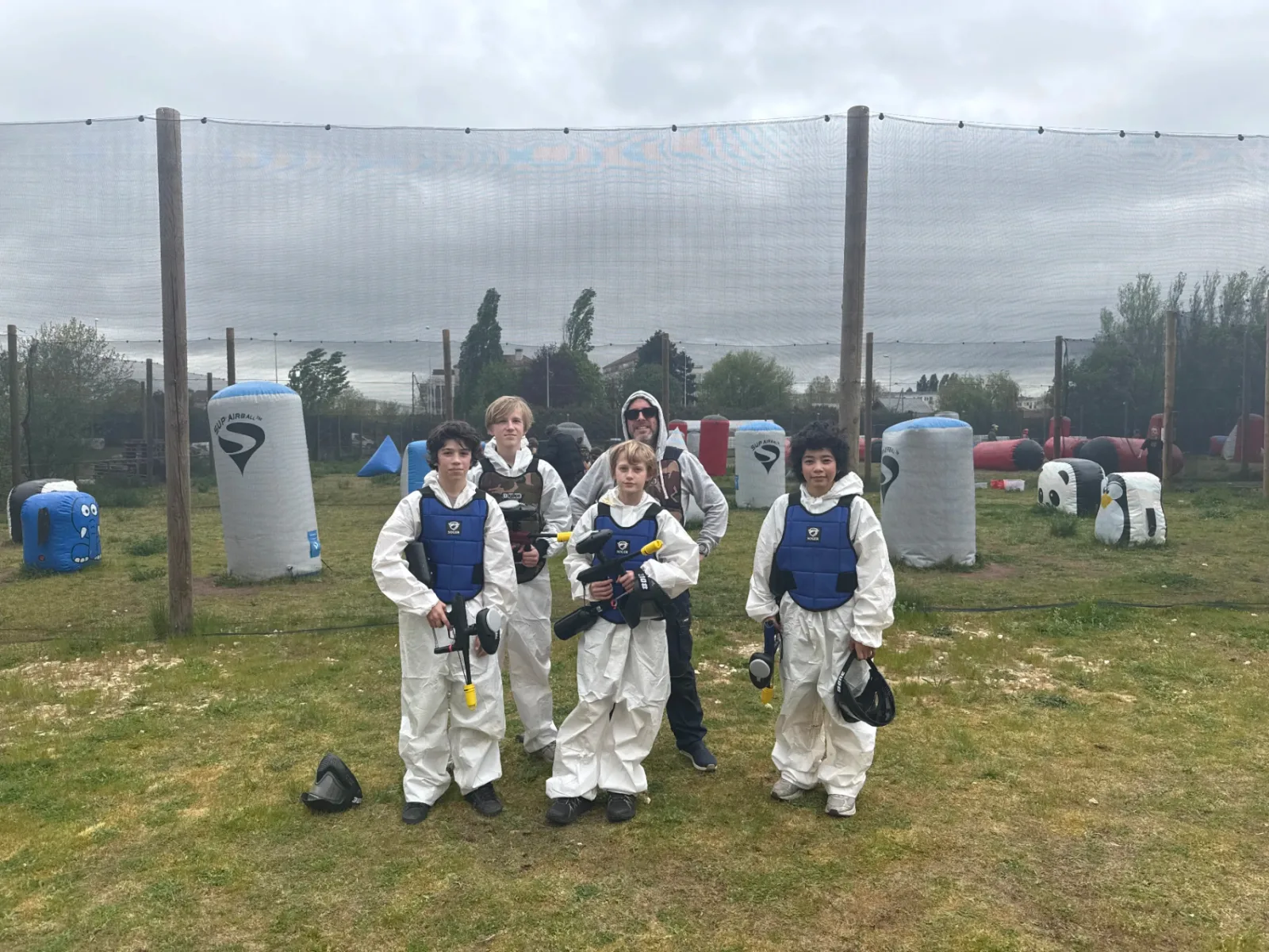 Groupe paintball en combinaisons intégrales sur terrain airball outdoor