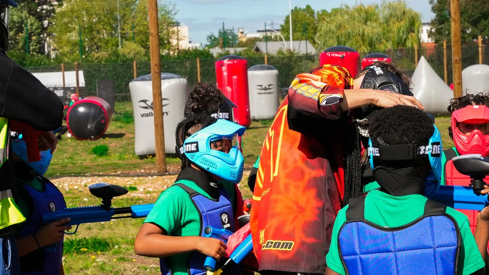 Moniteur équipant les enfants avant une partie de paintball sur terrain airball