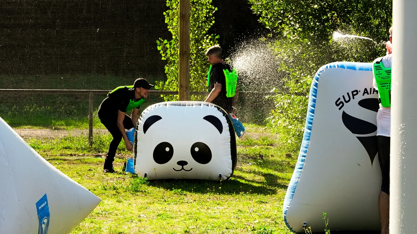 Groupe en Water Battle derrière obstacle gonflable panda sur terrain airball