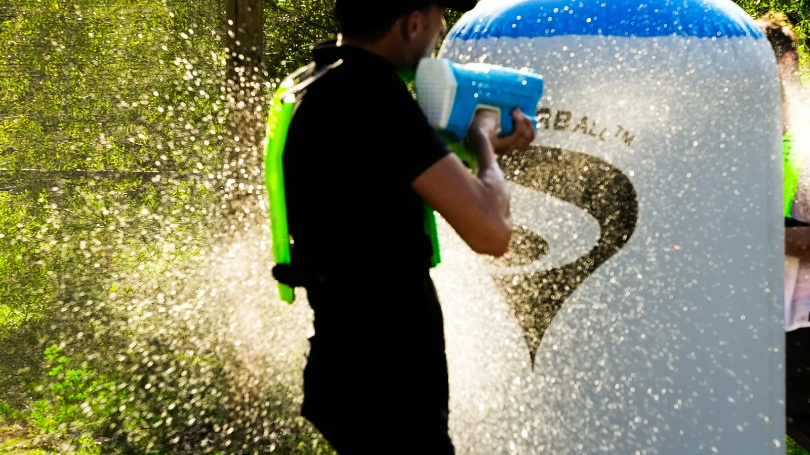 Joueur Water Battle équipé d'un lanceur bleu en action sur terrain airball