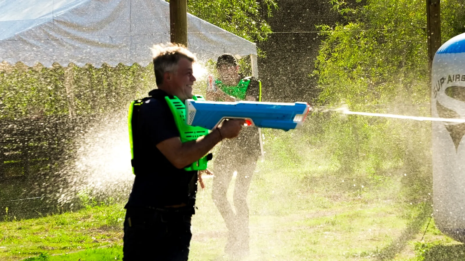 Joueur Water Battle tirant un puissant jet d'eau avec lanceur bleu